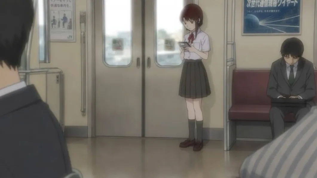 制服姿の玲音が電車内で端末を操作している場面
