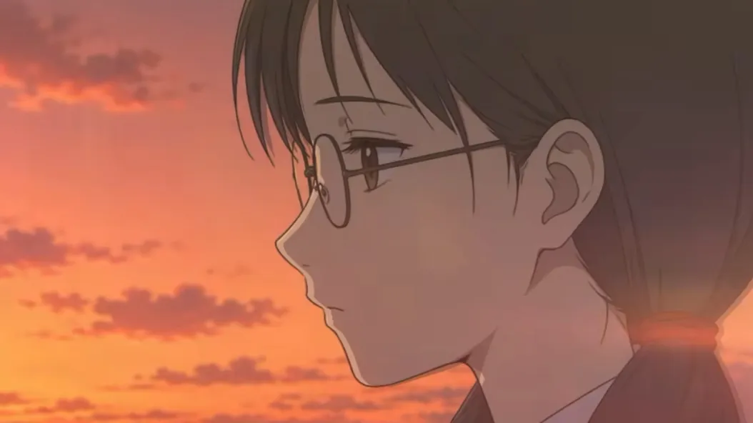 夕焼けを背に横顔を見せる眼鏡をかけた人物