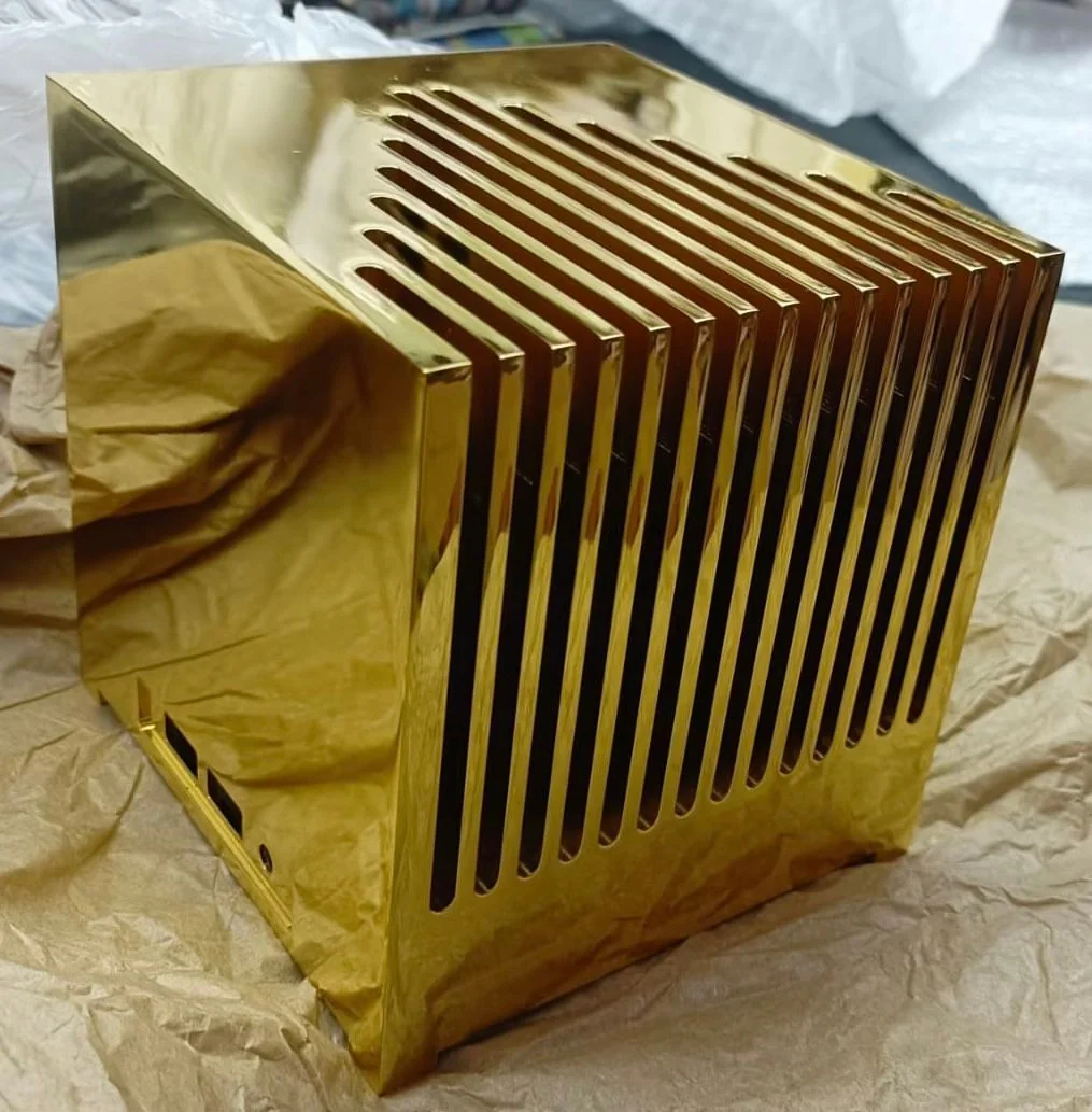 金色の鏡面に仕上げられたKubb Fanlessの筐体。立方体の天面から側面にかけて縦フィンが並び、背面側にI/O用の開口がある