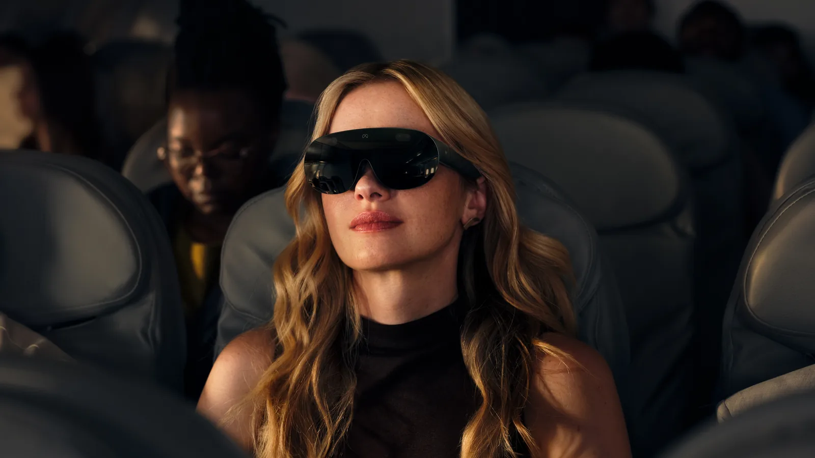 飛行機の座席でMeta VR Glassesをかけて映像を見ている女性