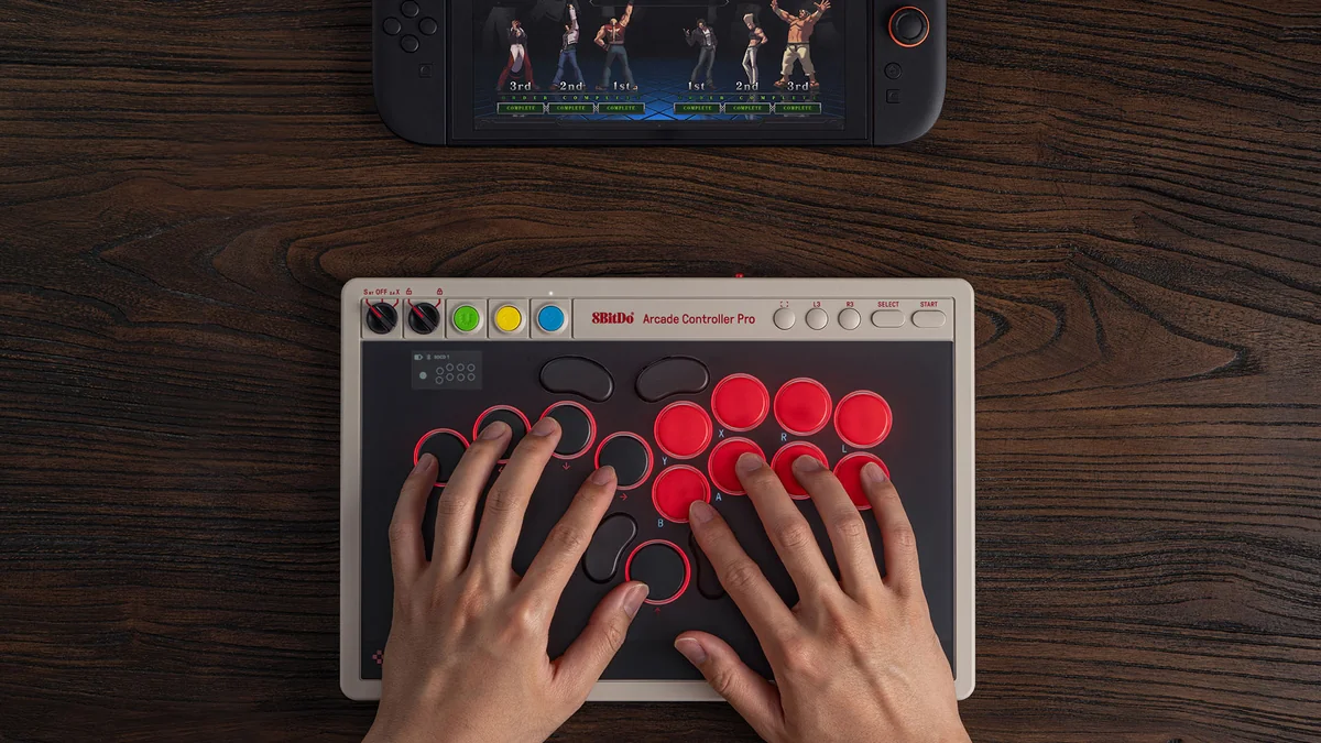 Arcade Controller Proを両手で操作する様子。Switchの画面に格闘ゲームが映っている